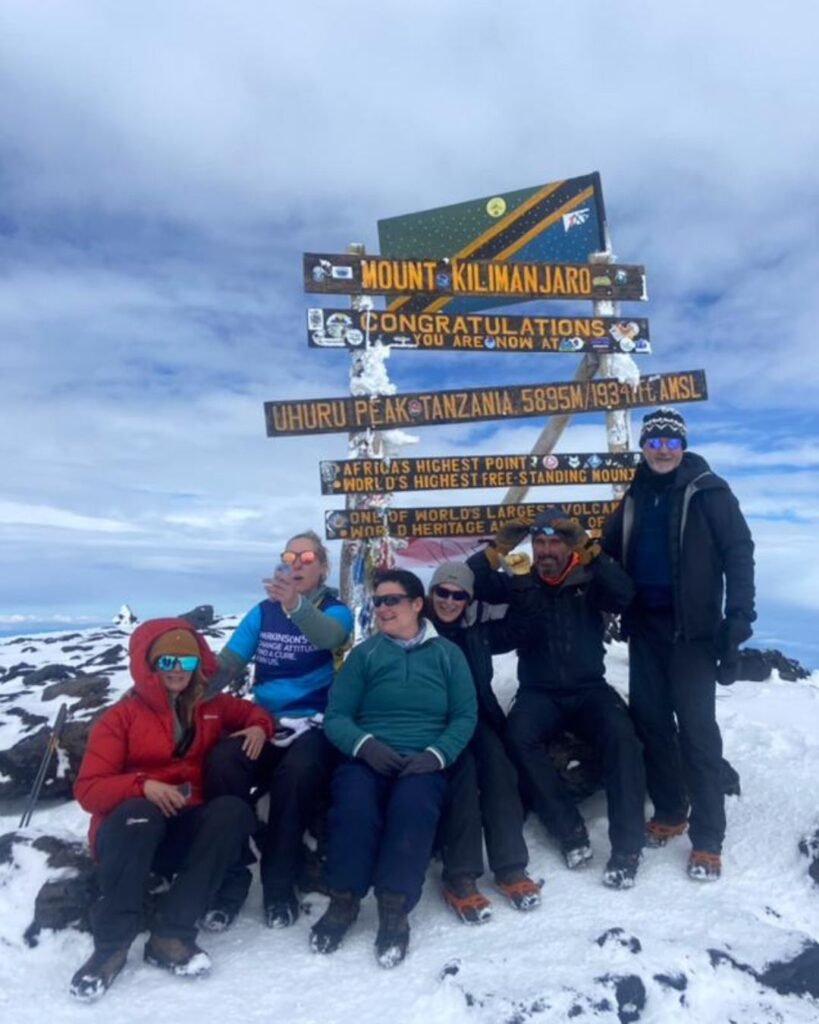 Climbers celebrating at Uhuru Peak Mount Kilimanjaro summit Tanzania