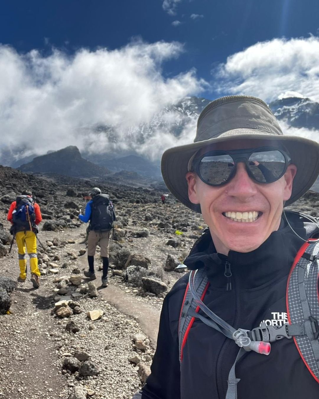 Happy climber trekking Mount Kilimanjaro during summit adventure in Tanzania