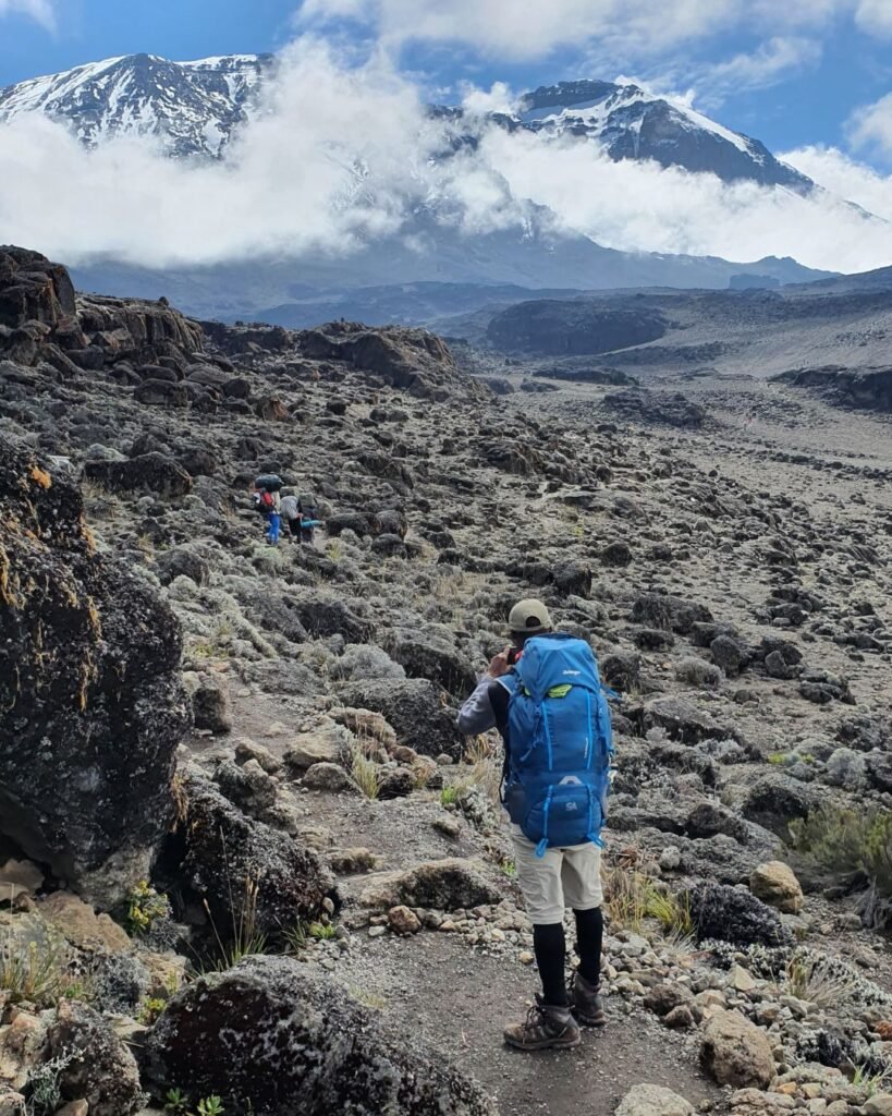 Professional Kilimanjaro guide leading climbers on a trekking route in Tanzania