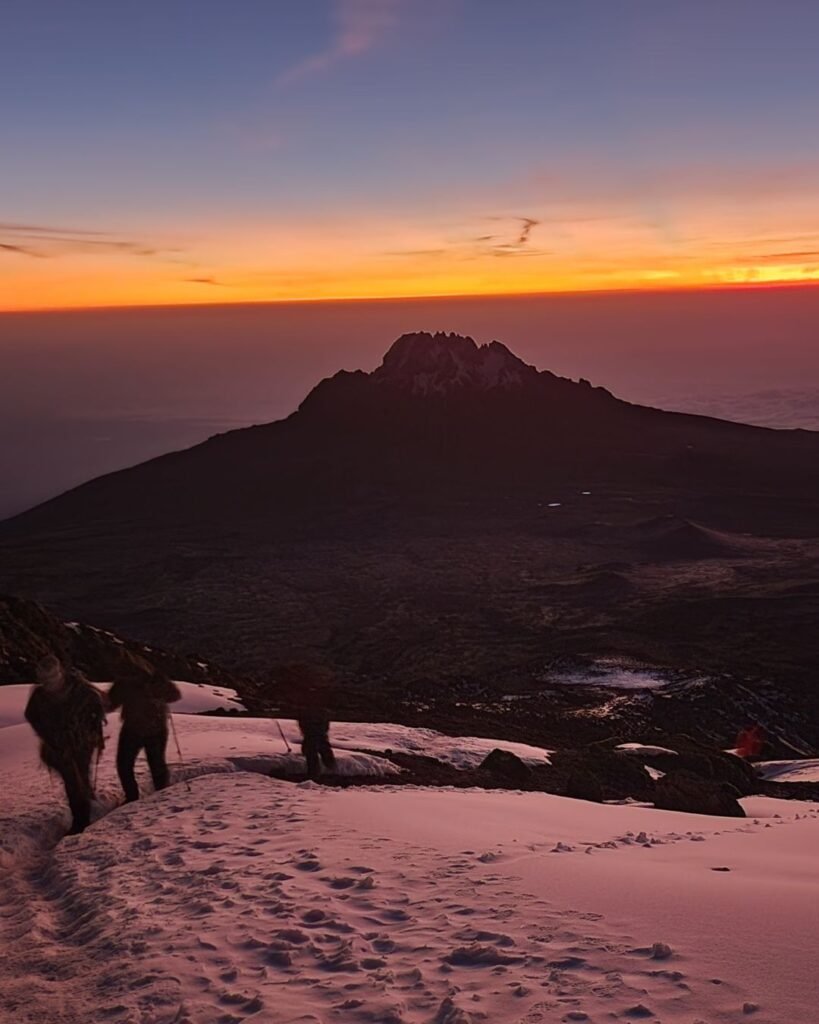 Climbers reaching the summit of Mount Kilimanjaro at sunrise in Tanzania