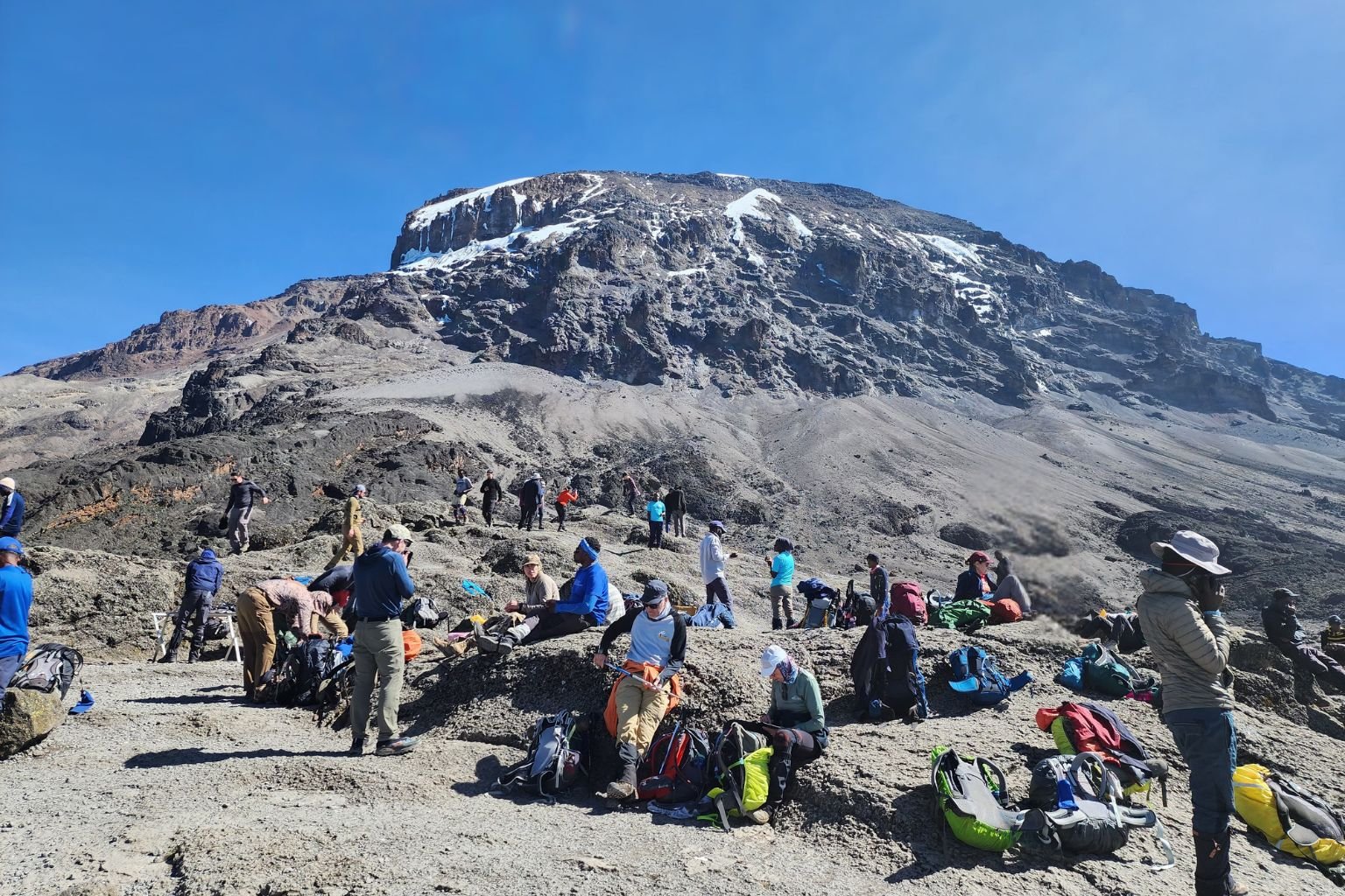 Climbers reaching the top of the Barranco Wall on Mount Kilimanjaro with scenic mountain views