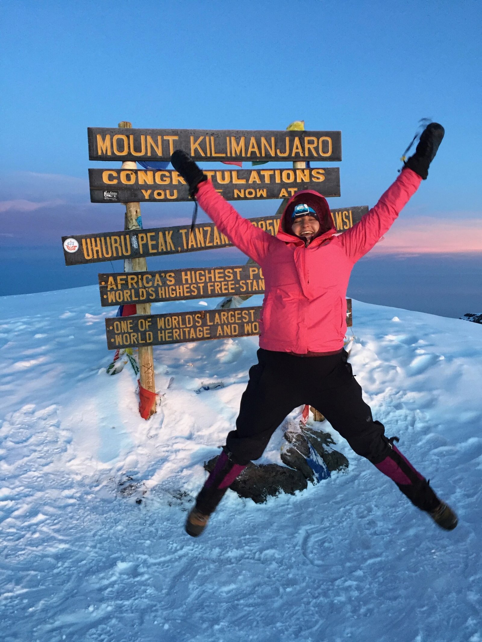 Climber celebrating at Uhuru Peak summit on Mount Kilimanjaro during a successful summit day