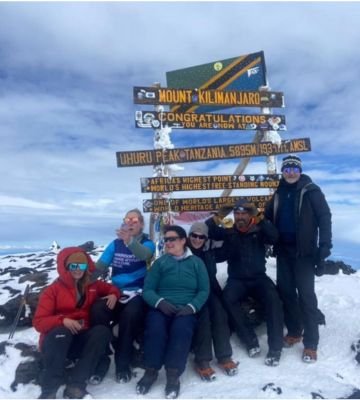 Climbers celebrating at Uhuru Peak Mount Kilimanjaro summit Tanzania Africa