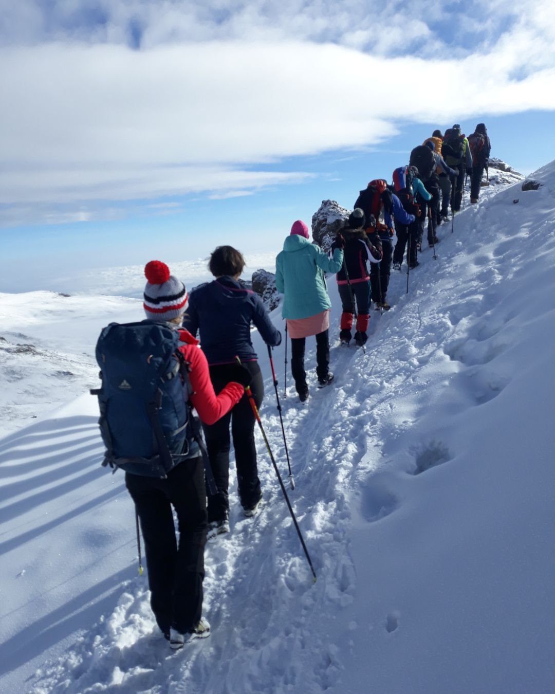 Climbers hiking toward the summit of Mount Kilimanjaro on a snowy summit trail