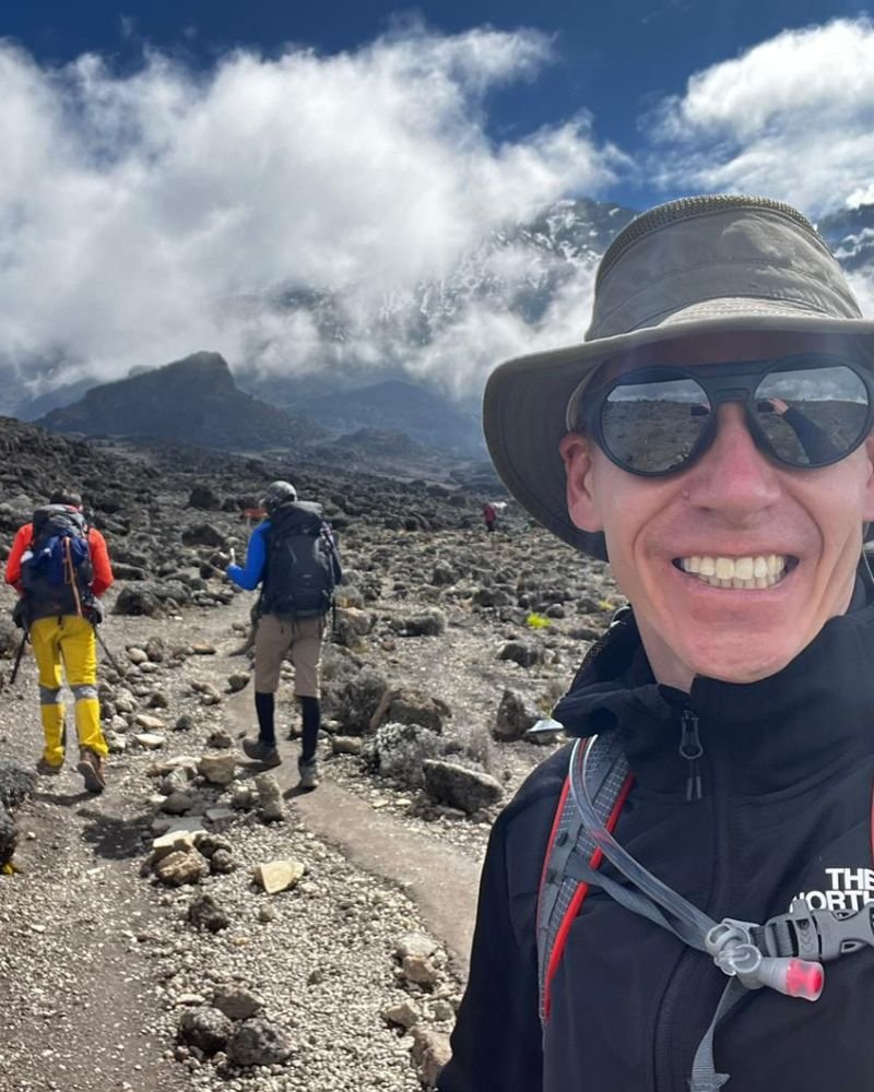 Happy climber with Kilimanjaro Summit guides during a successful Mount Kilimanjaro trekking adventure in Tanzania