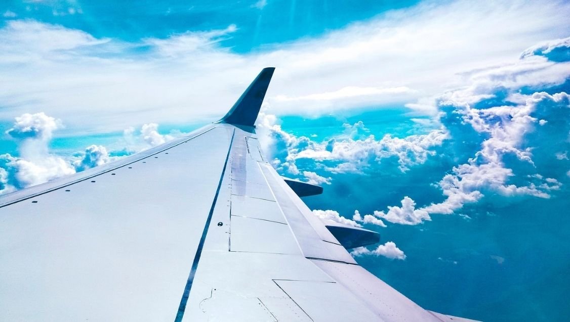 Airplane wing above the clouds on a flight to Zanzibar