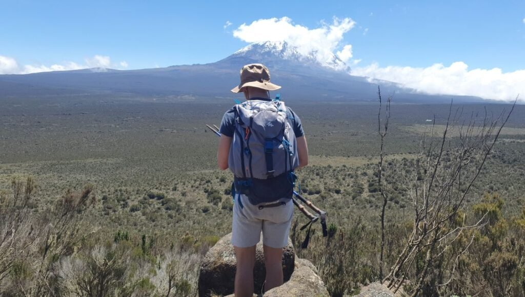 Hiker on the Mount Kilimanjaro Northern Circuit Route with Kibo Peak in the background, Tanzania.
