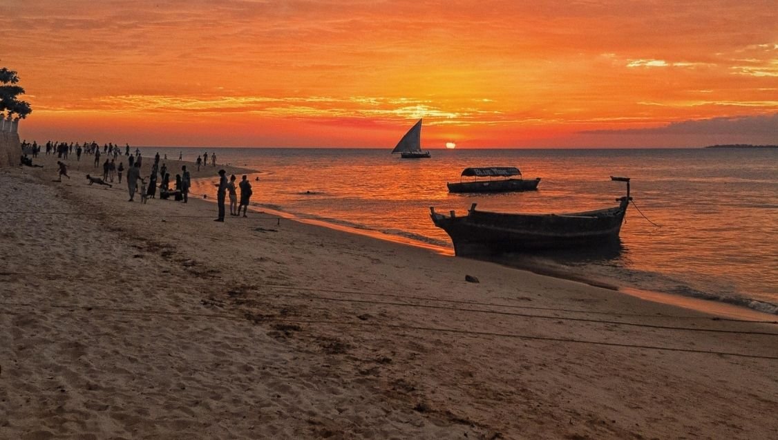 Zanzibar beach at sunset with traditional dhow boat in Tanzania