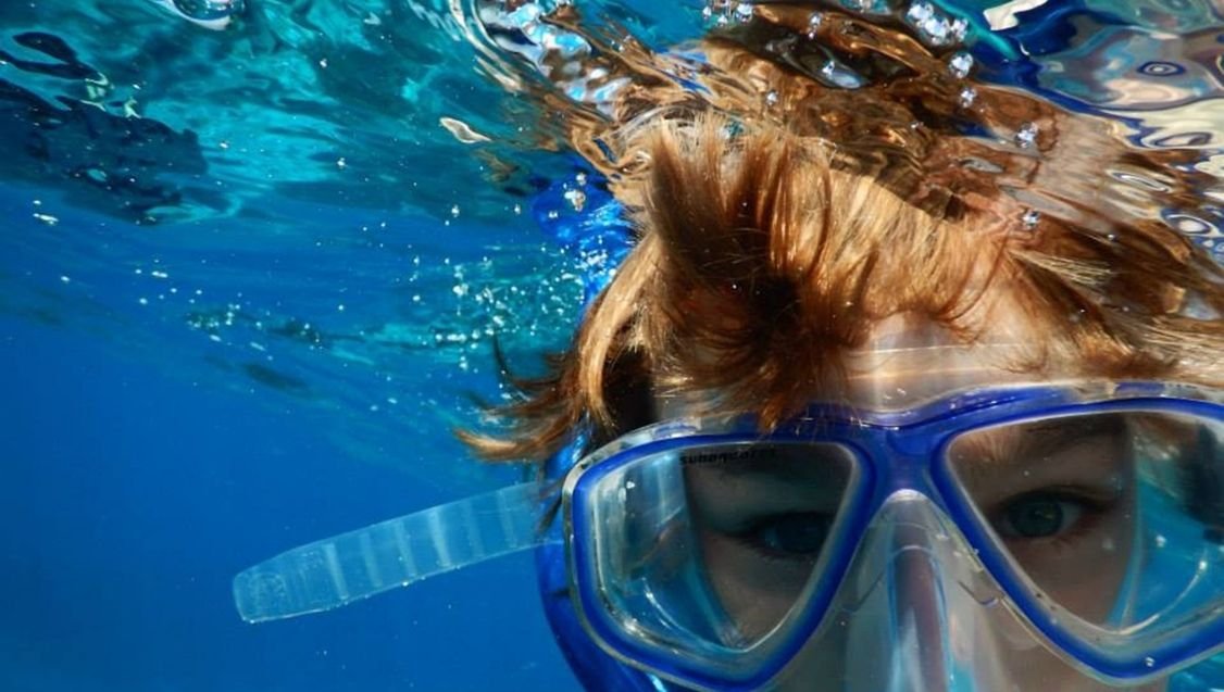 Person snorkeling in the clear blue waters of Zanzibar